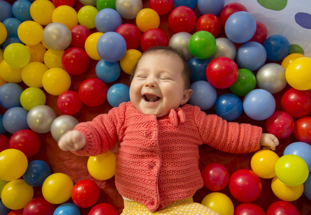 A baby playing in the ball pit