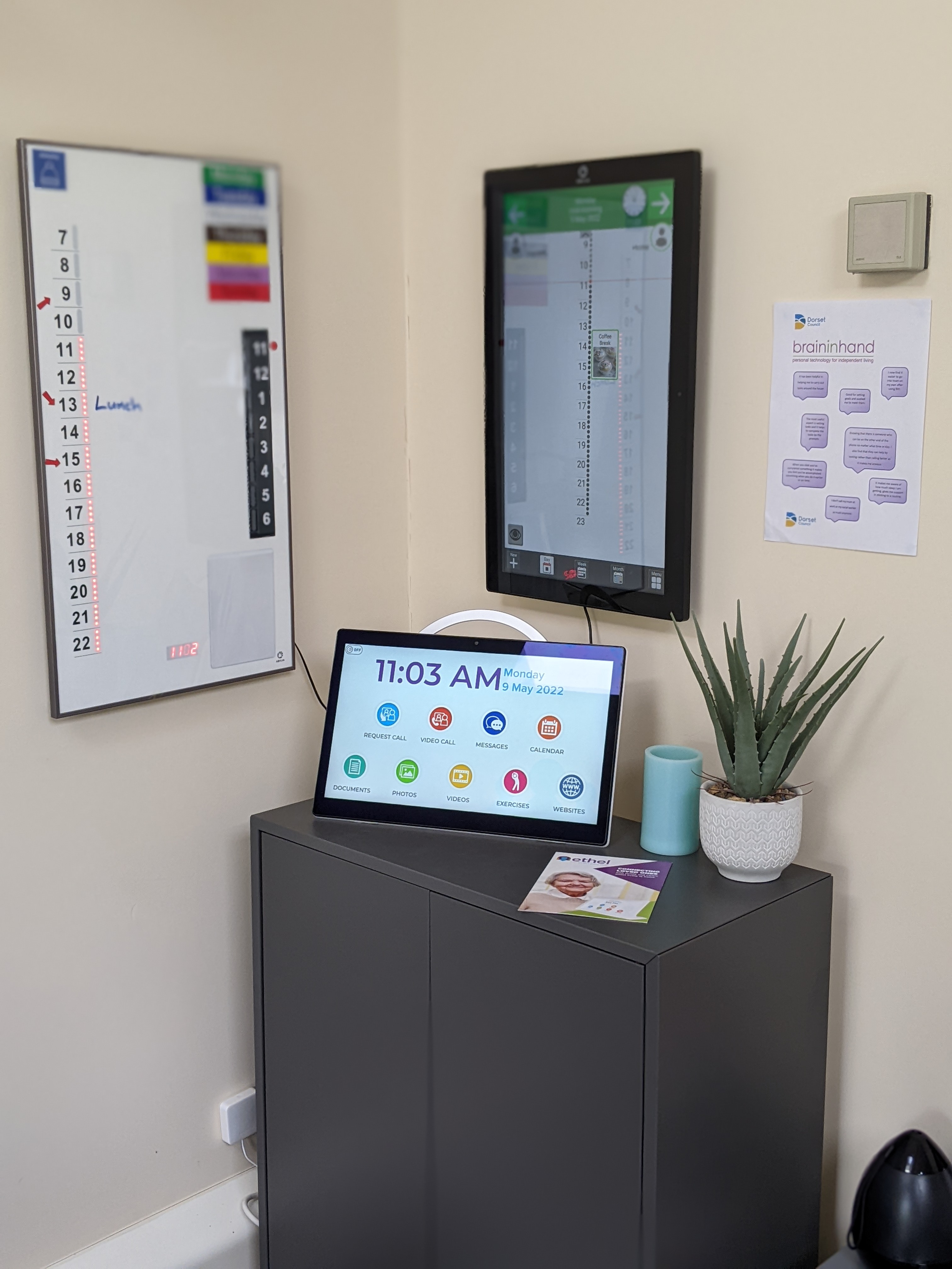 A tablet showing the time, on a cabinet