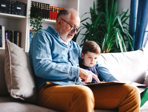 Adult reading to child on a sofa